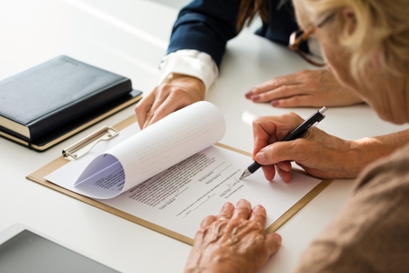 woman signing document in lawyer's office